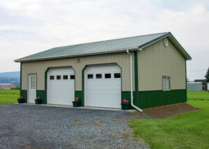 Post from garage with tan metal siding, green metal trim and roof.