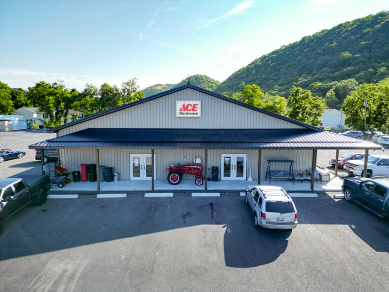 Side view of an Ace Hardware with a shiny black G-Rib roof with clay siding