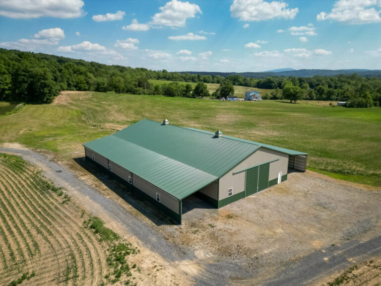 barn with an evergreen standing seam roof and clay siding